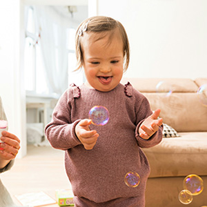 Child with Down syndrome playing with bubbles