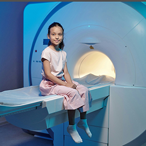 Girl sitting next to MRI